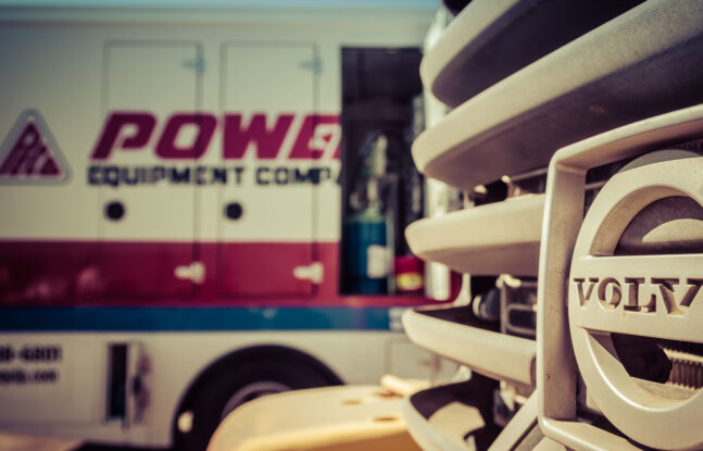 Power Equipment Company service truck positioned behind a piece of Volvo construction equipment.