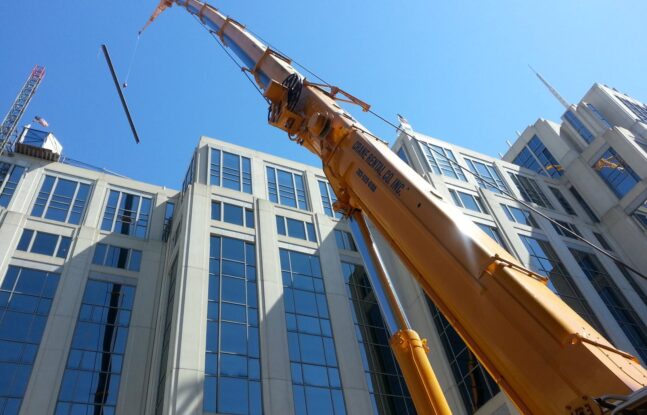 Crane Rental Company lifting beams on top of large building in Washington, D.C.