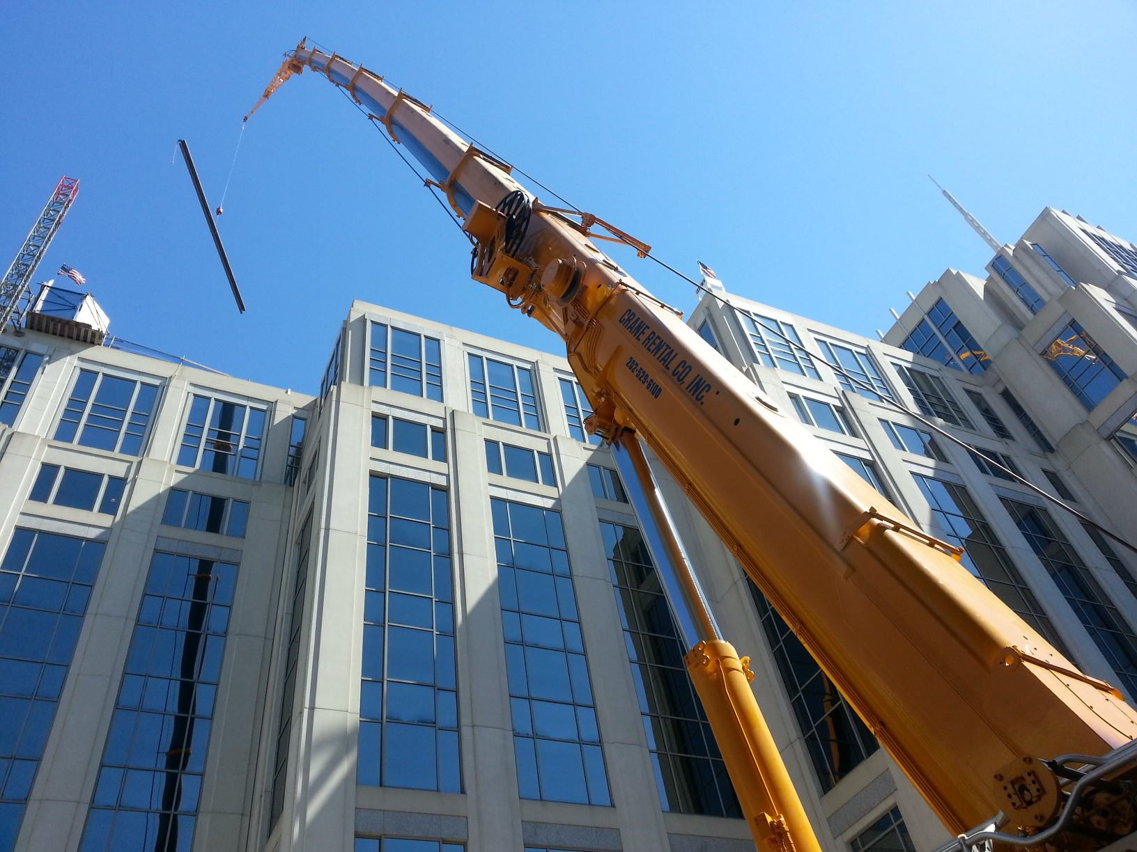 Crane Rental Company lifting beams on top of large building in Washington, D.C.
