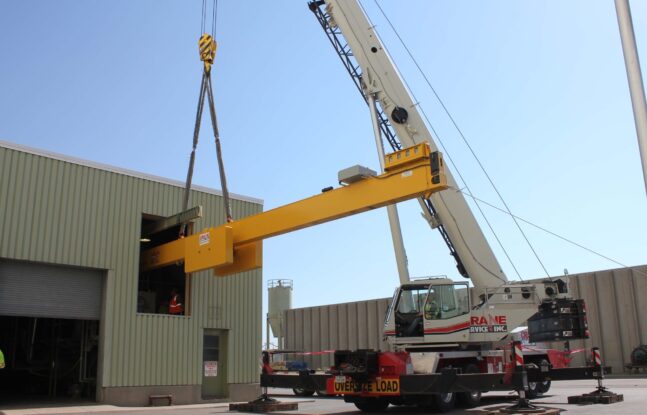 Crane Service lifting a cantilever beam into second story entryway in building