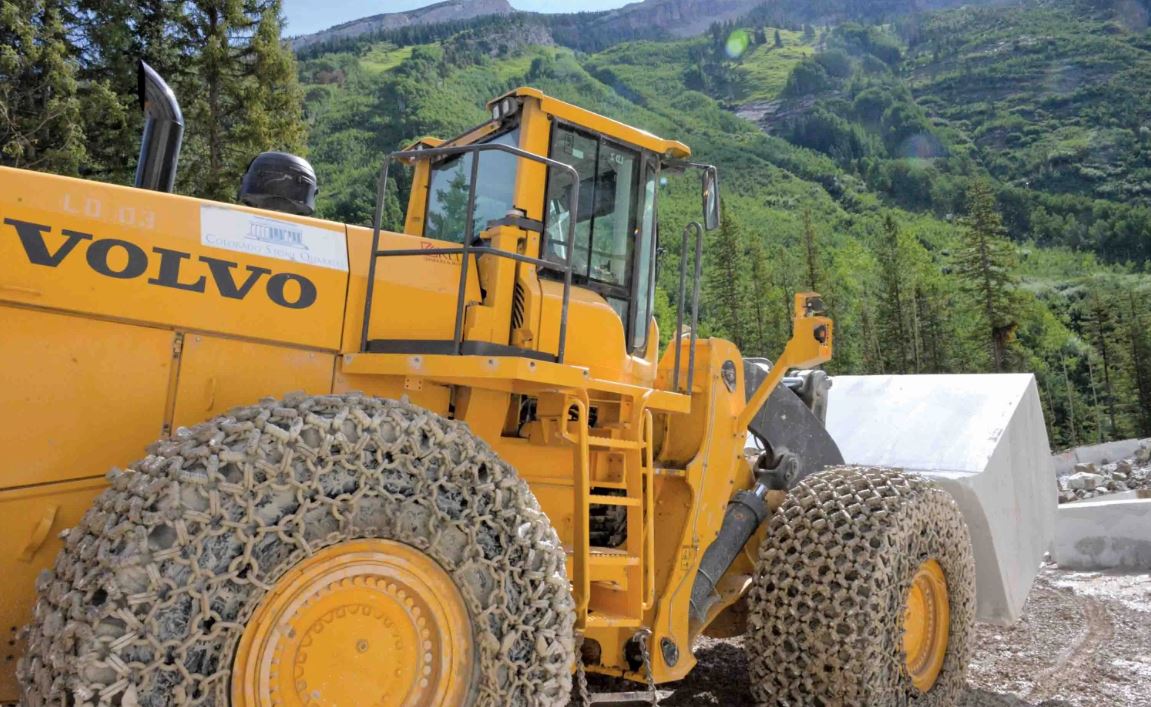 A large Volvo wheel loader is hauling marble stone at a quarry in Colorado